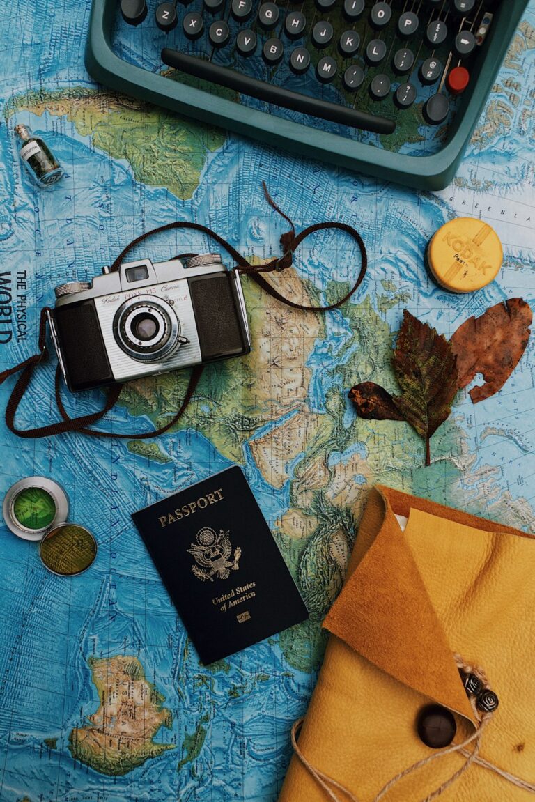 Traveler reviewing a passport, itinerary, map, and packing checklist at a kitchen table.